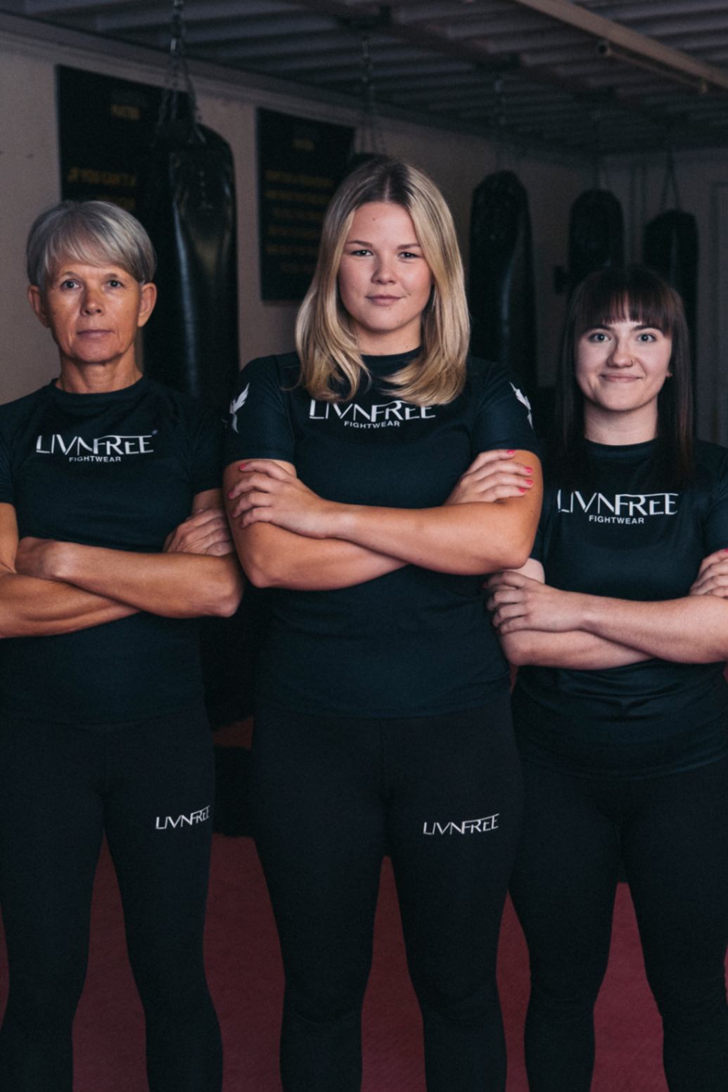Drei Frauen in Kampfsportkleidung von Livnfree Fightwear im Fitnessstudio – funktionale Sportleggings und Rashguards speziell für Frauen, die Stärke und Zusammenhalt im Kampfsport zeigen.