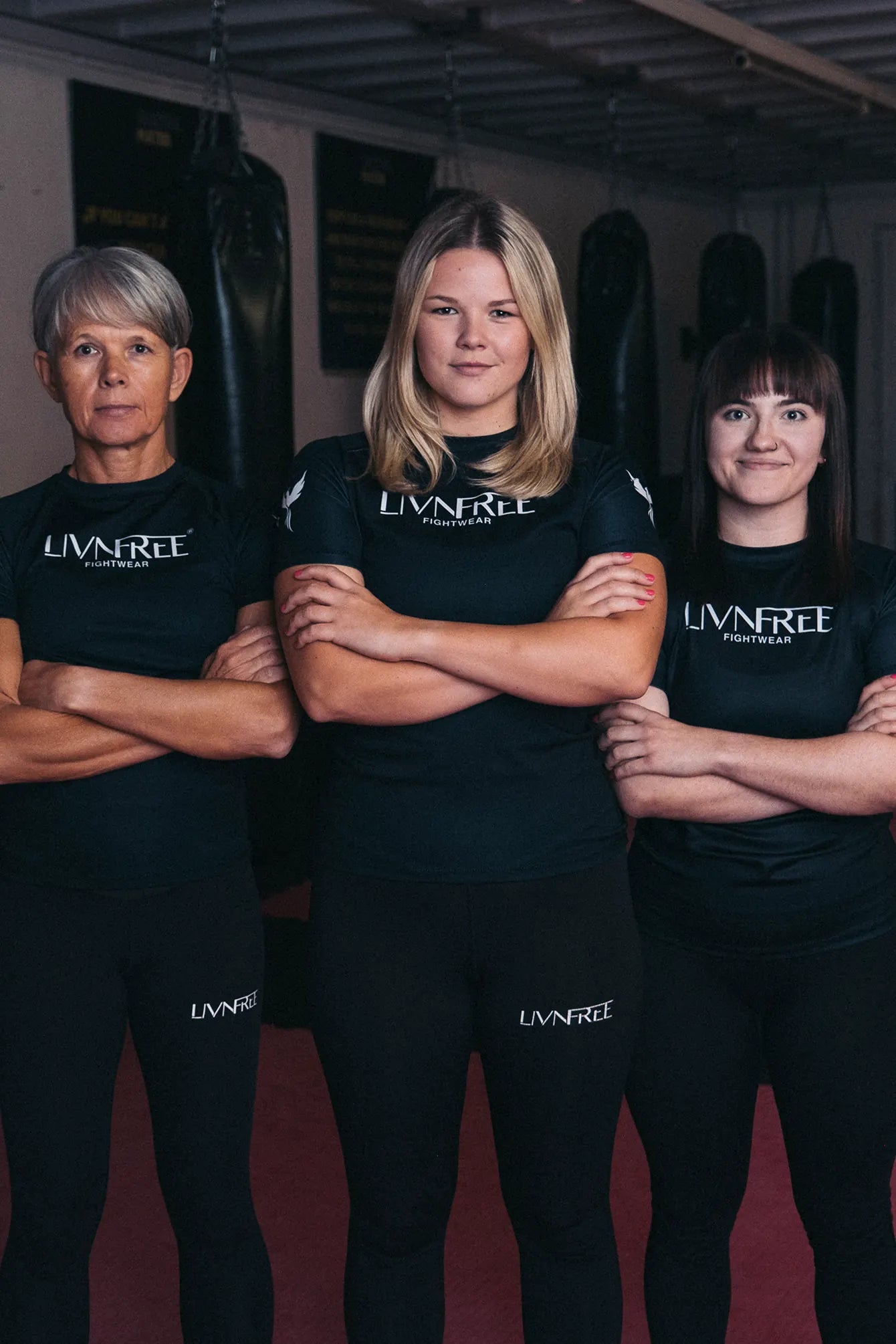 Drei Frauen in Kampfsportkleidung von Livnfree Fightwear im Fitnessstudio – funktionale Sportleggings und Rashguards speziell für Frauen, die Stärke und Zusammenhalt im Kampfsport zeigen.