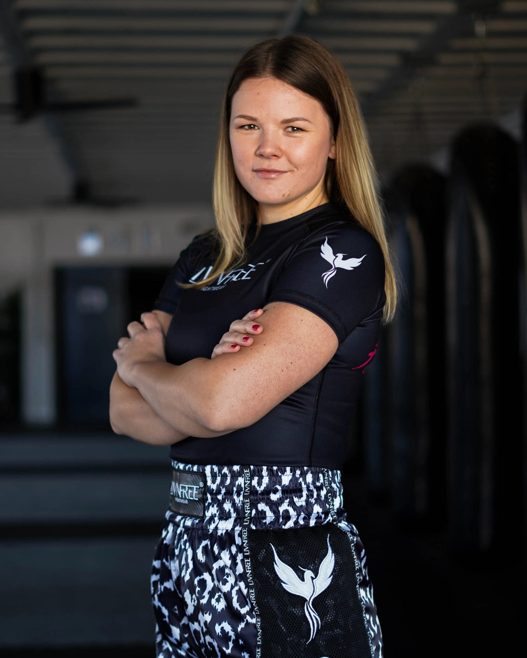 Gründerin Hannah von Livnfree Fightwear seitlich lächelnd in die Kamera in einem Kampfsportstudio