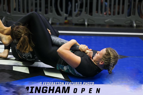 Frau in einer Brazilian Jiu-Jitsu Grappling-Position auf einem Wettkampf-Mattenboden während eines Turniers