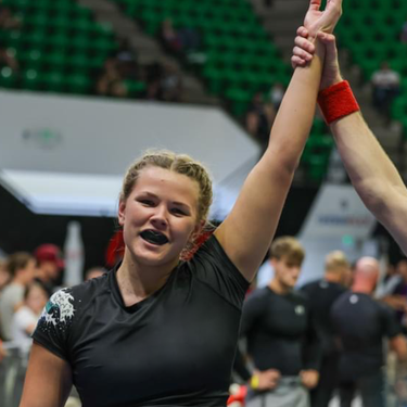 Frau in einer Brazilian Jiu-Jitsu Grappling-Position auf einem Wettkampf-Mattenboden während eines Turniers